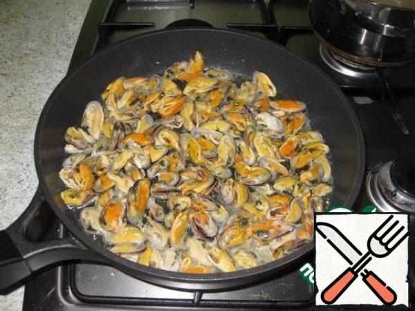 Put the mussels in a preheated frying pan with olive oil. Fry for 5 minutes on high heat.
