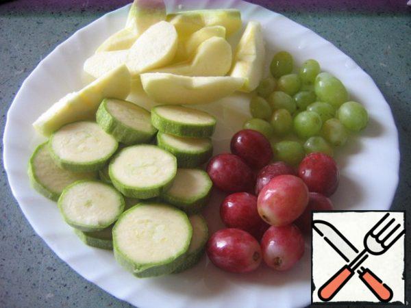 Cut the zucchini into slices. Peel the apple, remove the core, cut into slices. Cut the grapes from the bunches, rinse.
