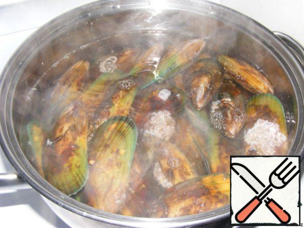 In a wide saucepan, bring the water to a boil. Turn off the stove and lower our mussels into boiling water for 10 minutes.

