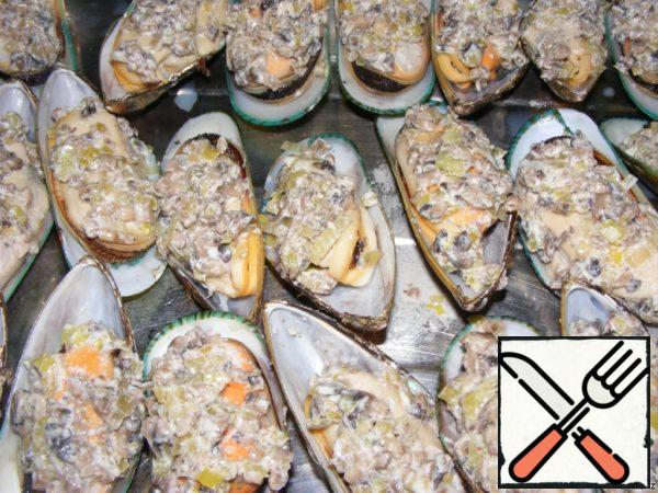 The filling is spread on the mussels.
