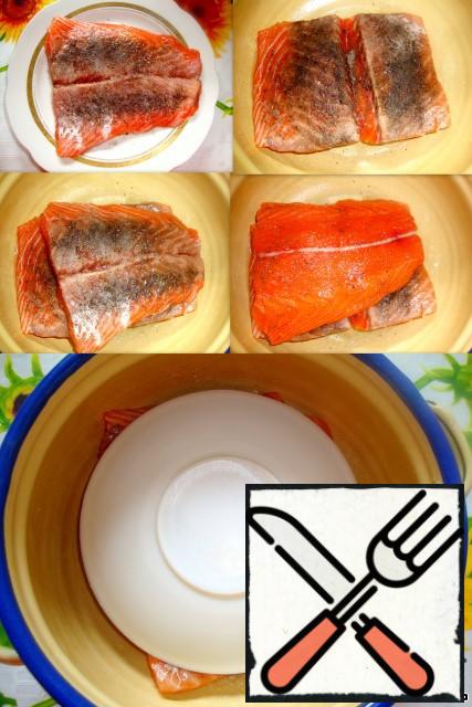 On the back will make an incision to better and faster salted salmon.
Add salt, sugar, pepper.
Cover with a plate and refrigerate.