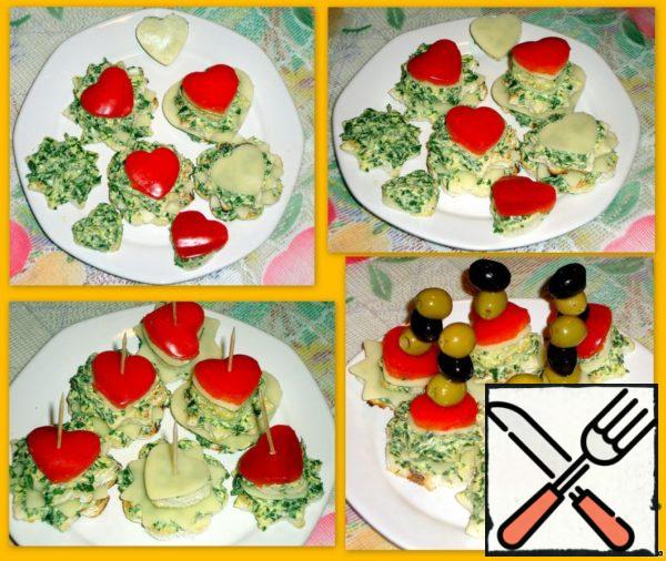 Canapes with cheese. Cut the cheese and pepper cores into molds. Lay out several rows. Secure with skewers. String olives on skewers.
