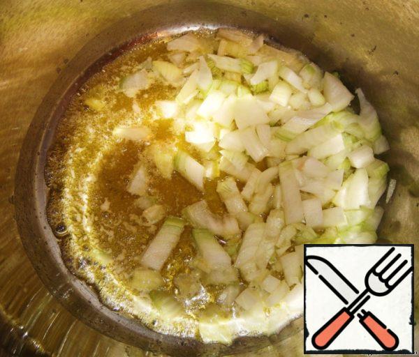 For starters need to take a deep pan, to which necessarily there is lid.
Put the pan on the fire and melt the butter in it. Lightly fry in it finely chopped onion and garlic for about 5 minutes.