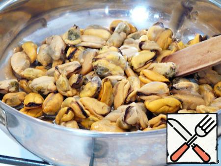 Thaw the mussels, rinse under running water.
Lay out on pan, with vegetable oils.
Simmer on low heat until then, until almost all the juice has evaporated
(approximately 7 minutes).
