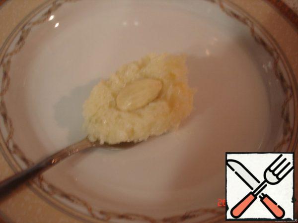 Take a teaspoon of the mass, put the almonds inside and form a ball.
