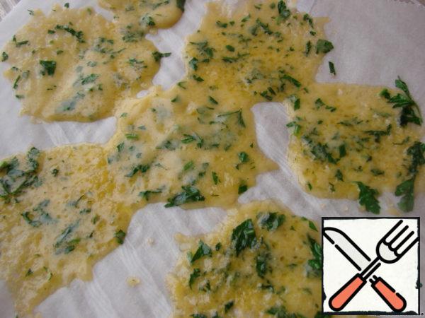 Grate cheese, finely chop greens, mix everything.
On a flat plate covered sheet of parchment, place the slices mixture and bake in microwave for 7-8 seconds.