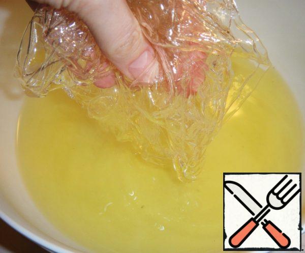 In the strained hot syrup add the swollen gelatin, previously wrung it of excess water. Mix thoroughly until the gelatin is completely dissolved.