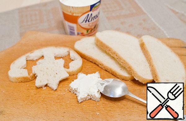 Bread cut into slices, cut the desired shape. I made stars with cookie cutter. Grease each slice with cottage cheese.