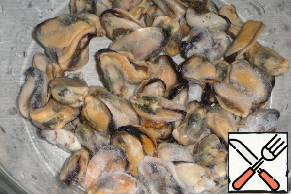Frozen (without shells) mussels defrost in the air, rinse thoroughly with warm water, removing the remnants of sand. Dip the mussels in cold water. Bring to a boil, add salt and pepper and cook over low heat for 10-15 minutes until the water is drained.
