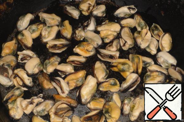 Mussels lay out in a deep pan.