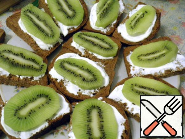 Ripe kiwi fruit peel, cut into thin slices and put on the greased bread.