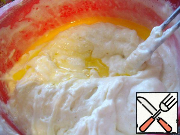To the proteins, add whipped yolk mass, gently mix. Add the flour gently, mix gently, but well, as if from top to bottom. Gradually add the melted and cooled oil.