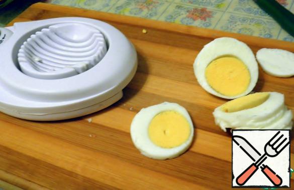 First, boil the hard boiled eggs. I always add a little salt to the water when cooking-even if the eggs are cracked, they will not leak out. Clean boiled eggs and cut into thin slices. I for these purposes there is a special thread, so that the time it took two minutes.