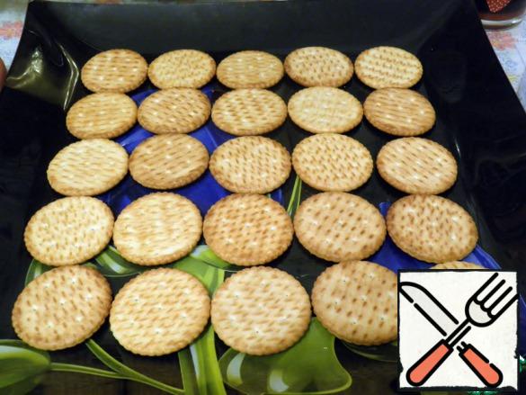 Preparations are complete, you can start assembling the canapes. Spread the crackers on the dish.