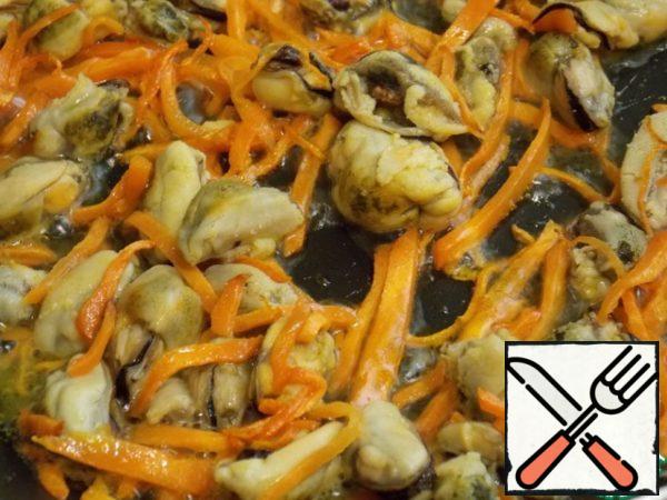 Heat the oil in a frying pan and fry the carrots cut into small strips for 3 minutes. Add the thawed and scalded mussels (squeeze the liquid). Stir and fry for 2 minutes.