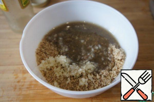 Add garlic to the nuts, pour the oil with vinegar into the nut crumbs and mix the mixture thoroughly.