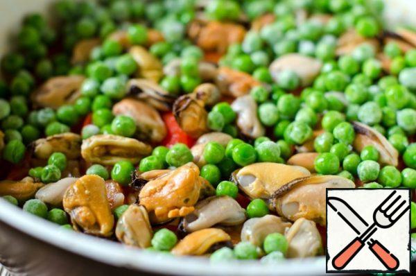 Then remove the foil and put the mussels and green peas, cover with foil again and cook until the broth is completely absorbed. Then increase the heat to the maximum and cook for 1 minute to get a crust of rice at the bottom of the pan.