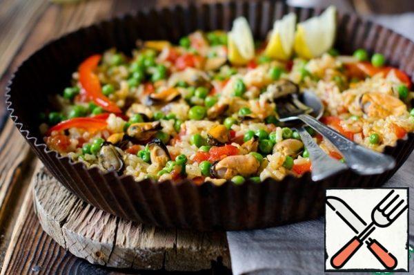 Then remove the rice from the heat and leave the paella for 10 minutes. After that, remove the foil and serve on the table, garnished with lemon slices.