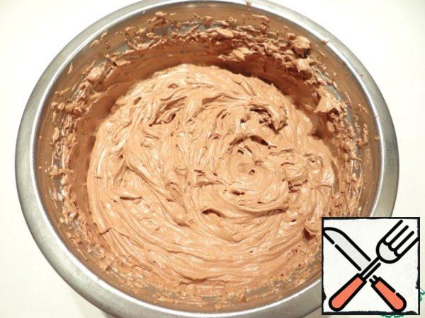 Mixing whipped cream and chocolate mass.
