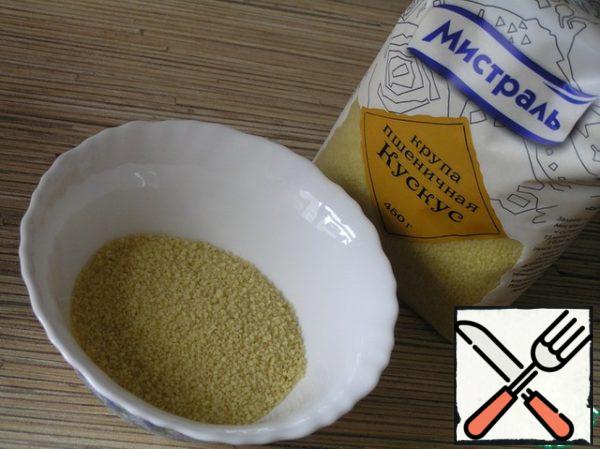 Meanwhile, boil the water 200 ml and pour the couscous, mix.