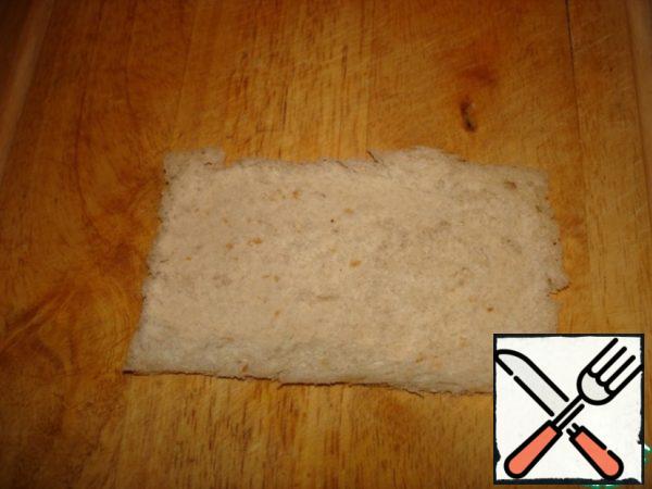 From the bread slices and cut off crusts and roll out with a rolling pin.