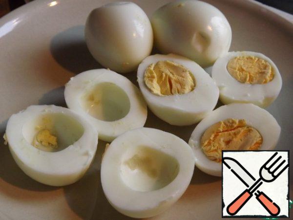 Boil the eggs, peel and cut along. Carefully remove the yolk.