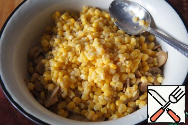 Corn also has to be drained, the grain is poured into a bowl with the salad.