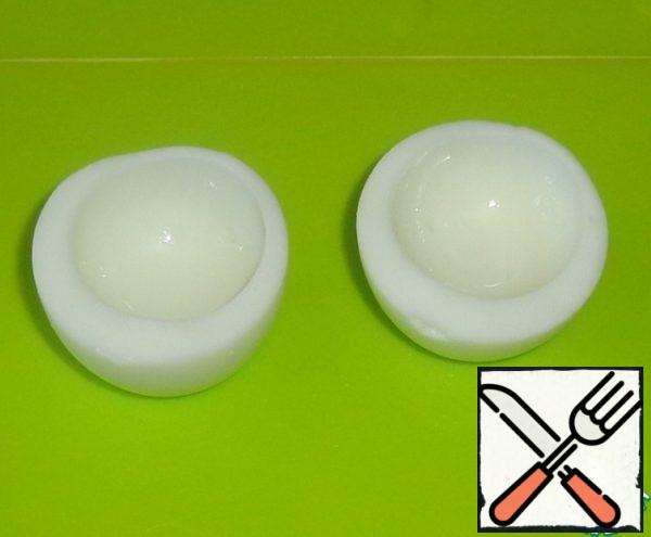 Boiled eggs clean the shell and cut into two equal parts. Remove the yolk. If desired, the yolk can be added to the filling.