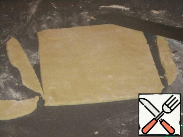 When rolling out the dough we try to give the most rectangular shape. Then still cut the rounded edges with a knife. The thickness of the roughly 5 mm.