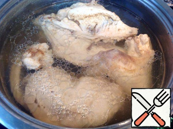 First, boil half of the chicken without skin.