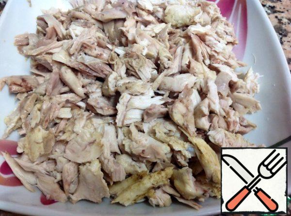 Chicken meat is separated from the bones and cut into small pieces.