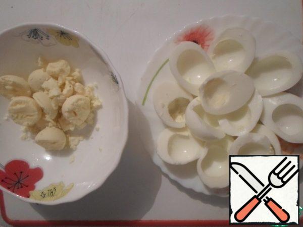 Eggs are cleaned from the shell, cut into 2 parts, separate the egg whites from the yolks.