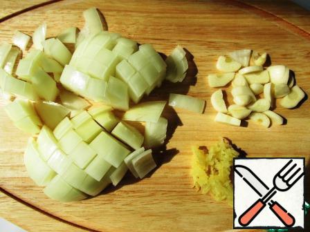 Onion cut into arbitrary, ginger grate on grater, a fresh garlic cut into slices.
