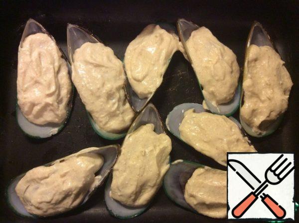 Carefully spread the sauce over the mussels with a teaspoon, trying to completely cover their flesh, and send them to a preheated 200 ° C oven for 15 minutes. Focus on your oven, you need the sauce on the mussels to get a light golden hue.
We take the finished mussels out of the oven and enjoy.