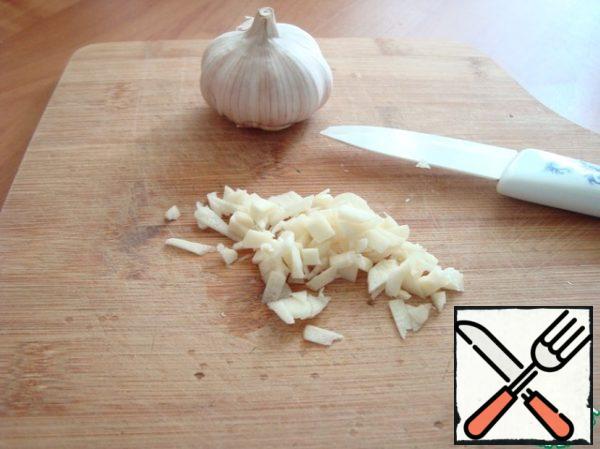 Chop the garlic finely and send it to a saucepan.