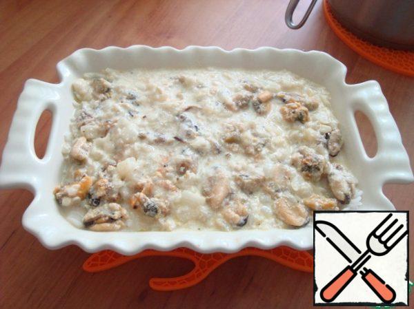 Put the cream sauce with mussels on top of the rice. Place in the oven for 15 minutes at t 180 °C. Focus on your oven.