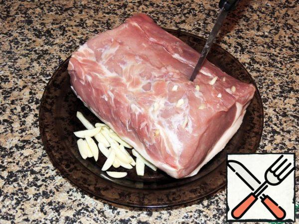 Peeled garlic cloves cut into thin cubes. Pork loin (suitable and lean neck) with a thin knife, making punctures in the meat, lard with garlic.