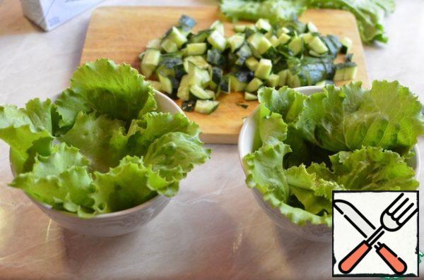 Wash lettuce leaves, dry them and put in salad bowls.