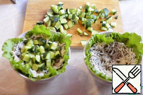 Place the chilled rice over the salad and spread over the salad bowl to make a recess in the rice. Lay in the deepening of cucumber, then chilled mussels.
Serve salad with a quarter of lemon, if desired, season with olive oil. Tasty, satisfying and easy!