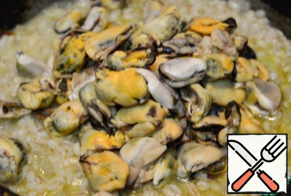 When the barley is ready, spread the thawed mussels. Add 2 more portions of broth and cook until the broth evaporates. Do not forget to stir to prepare evenly. That's all. The dish is ready. Serve with a glass of white dry wine.