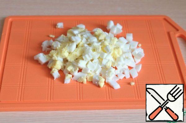 Boil chicken eggs and cut into small cubes.