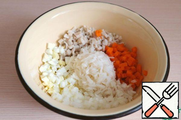 Combine in a bowl cut cubes of canned squid, onions, carrots, boiled eggs, add the washed boiled rice. Salt the salad to taste.