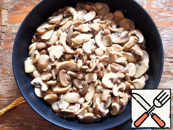 Drain the mushrooms and transfer them to a frying pan greased with olive oil.

