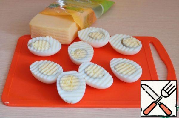 Boil chicken eggs, cut into two parts. Remove the yolk from the egg halves.
