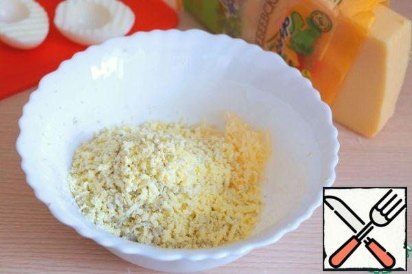 In a bowl add grated cheese, grated egg yolk.