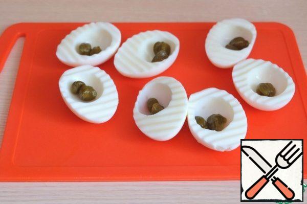 Add capers to each egg white.
