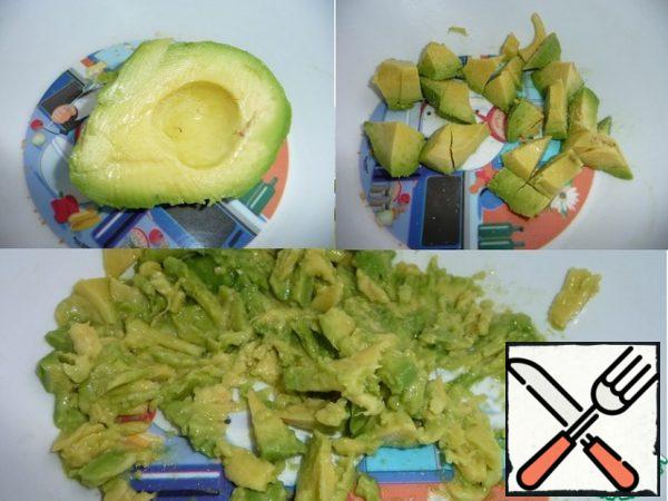 Avocado to peel. Cut into small pieces, sprinkle with lemon juice, add salt. Mash them with a fork.