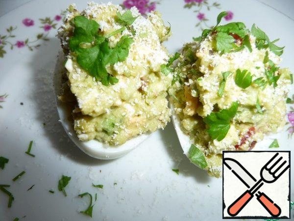 Fill halves of egg white filling, pepper, grate cheese. Decorate with greens.