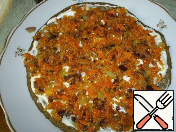 Brush a warm pancake with mayonnaise.
Lay out the carrots and onions.
Cover with the next pancake.
