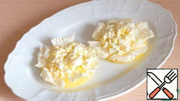 Put the chopped eggs on a layer of cabbage, lightly brush the layer with mayonnaise.
